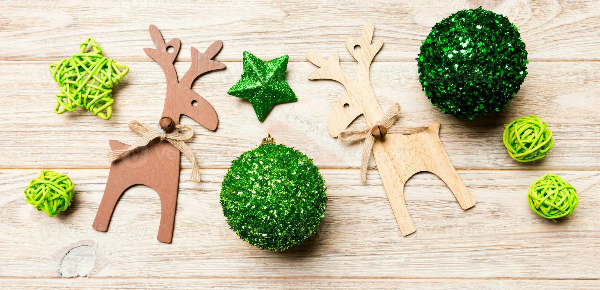 New Year composition made of baubles, reindeer and other decorations on wooden background. Christmas time concept with empty space for your design photo
