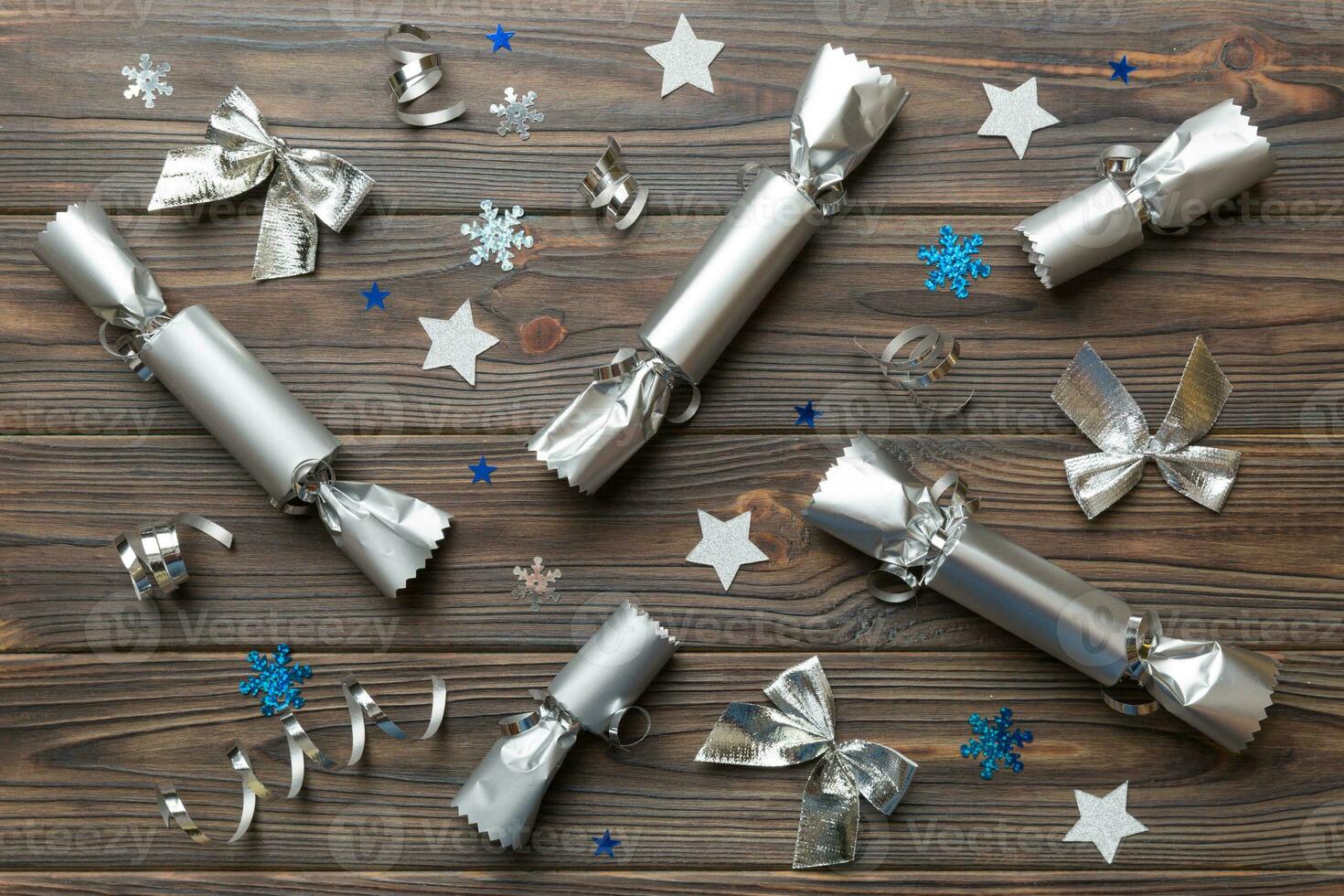 Christmas crackers with shiny confetti on color background, top view, copy space photo