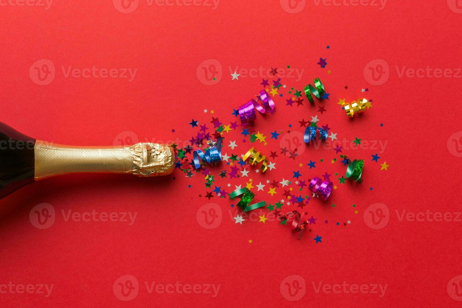 Creative flat lay composition with bottle of champagne and space for text on color background. Champagne bottle with colorful party streamers. holiday or christmas concept photo