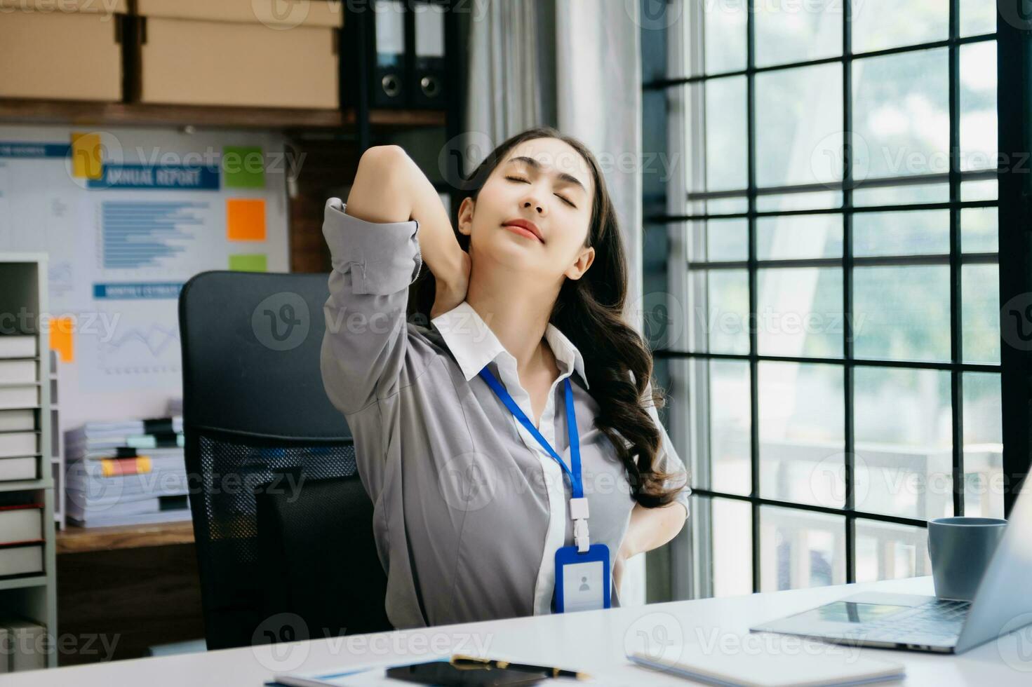 Asian woman feeling migraine head strain.Overworked businesswoman financier while working on laptop and tablet photo