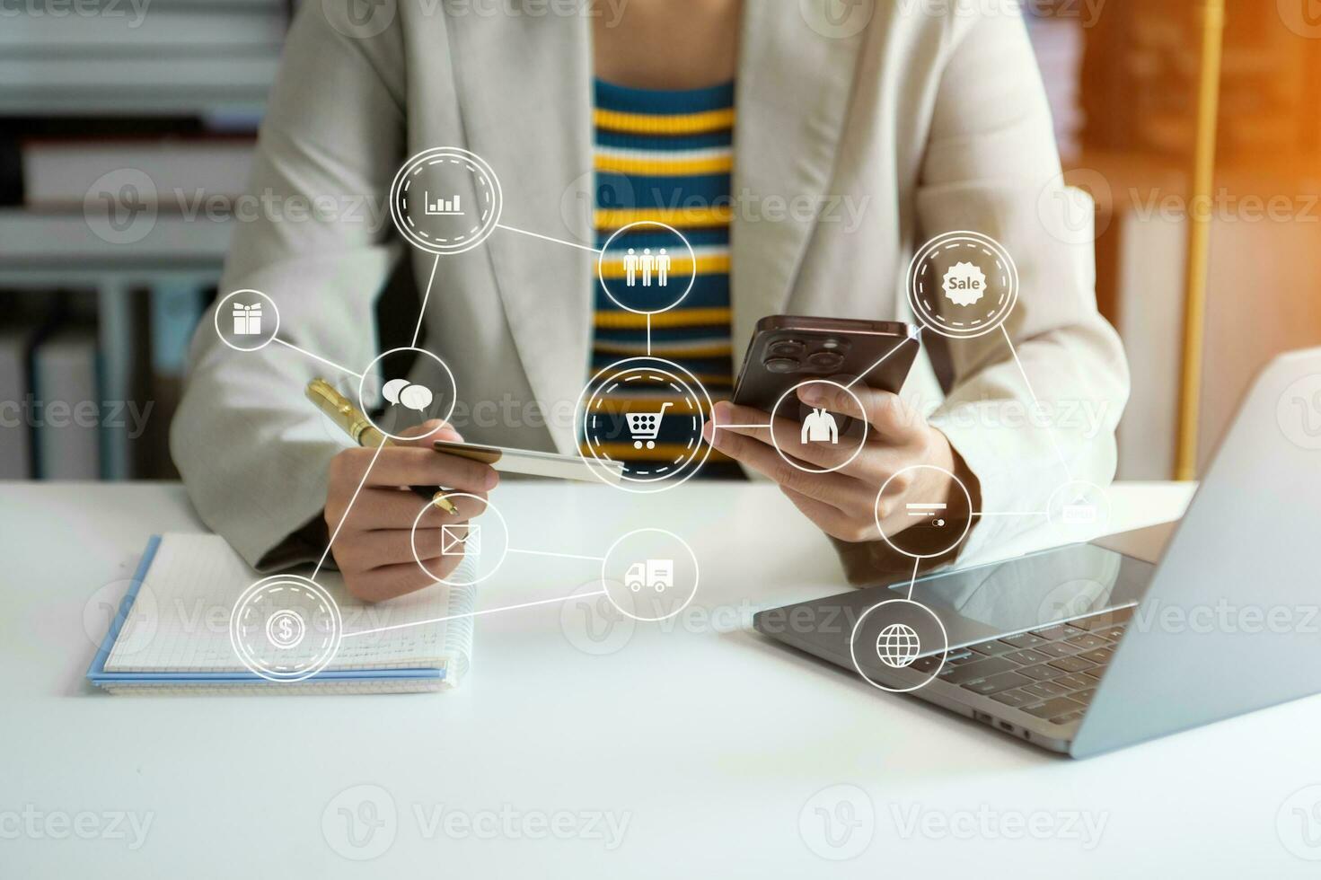 Woman using smart phone for mobile payments online shopping, omni channel, sitting on table, virtual icons graphics interface photo