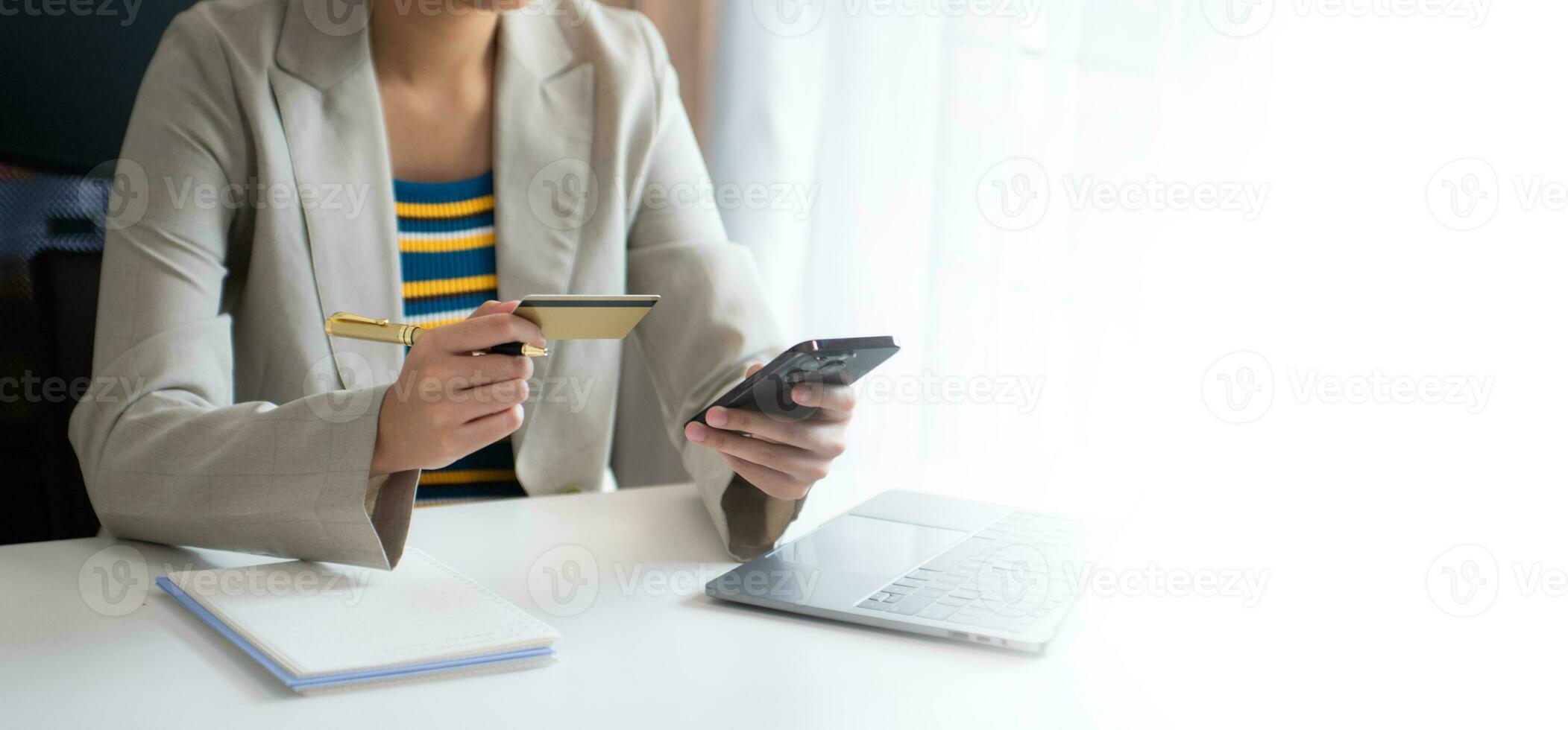 Woman using smart phone for mobile payments online shopping, omni channel, sitting on table, virtual icons graphics interface photo