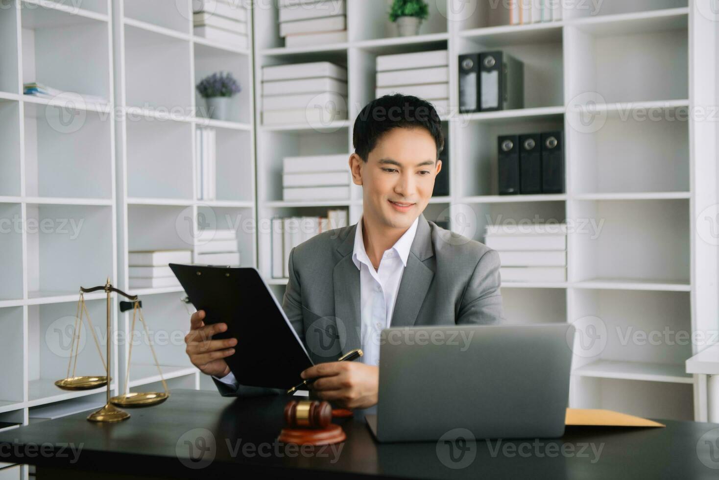 Attractive young lawyer in office Business man and lawyers discussing contract papers laptop and tablet with brass scale on  desk in office. photo
