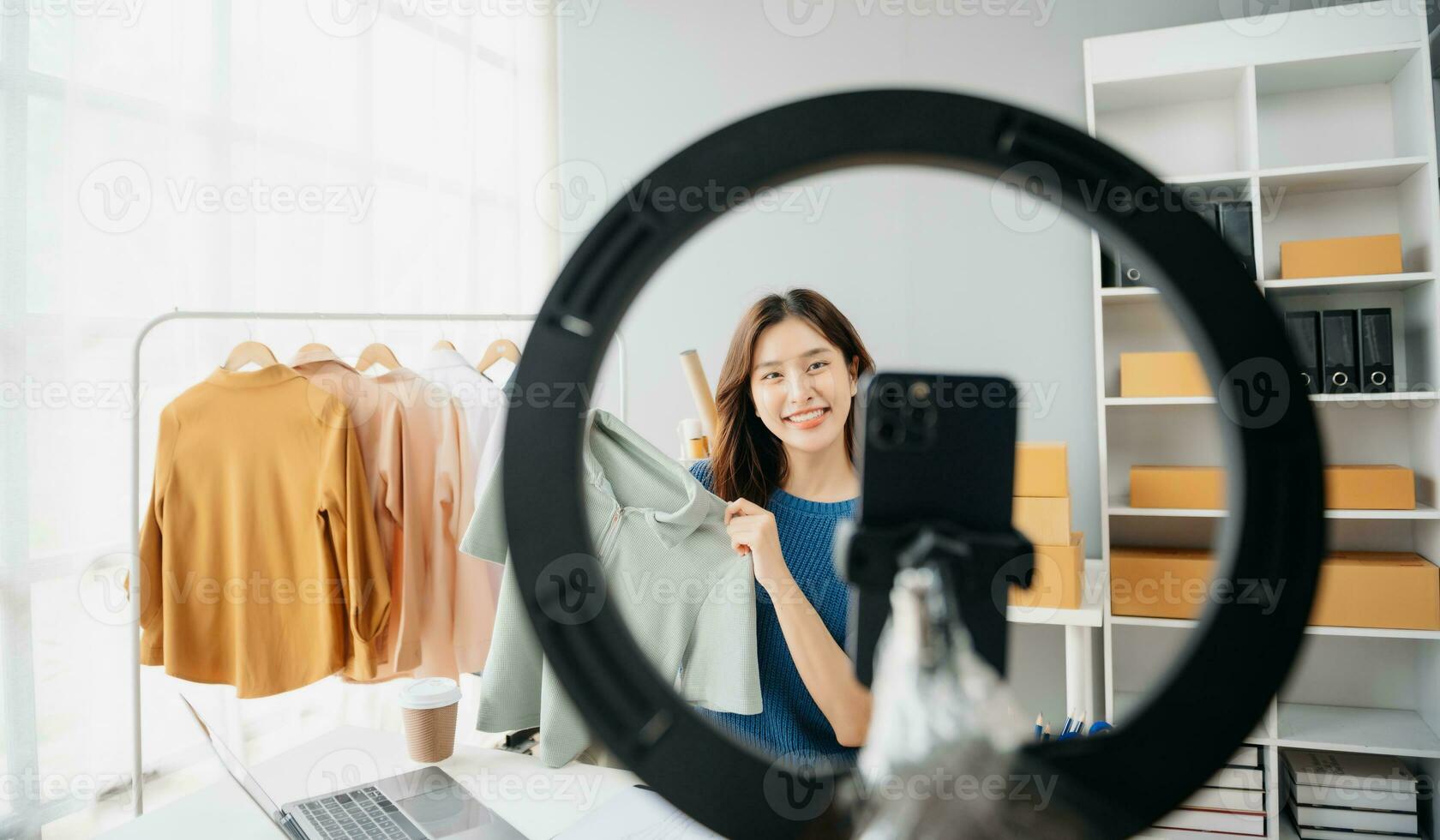 Asian lady blogger showing clothes in front of the camera to recording vlog video live streaming photo