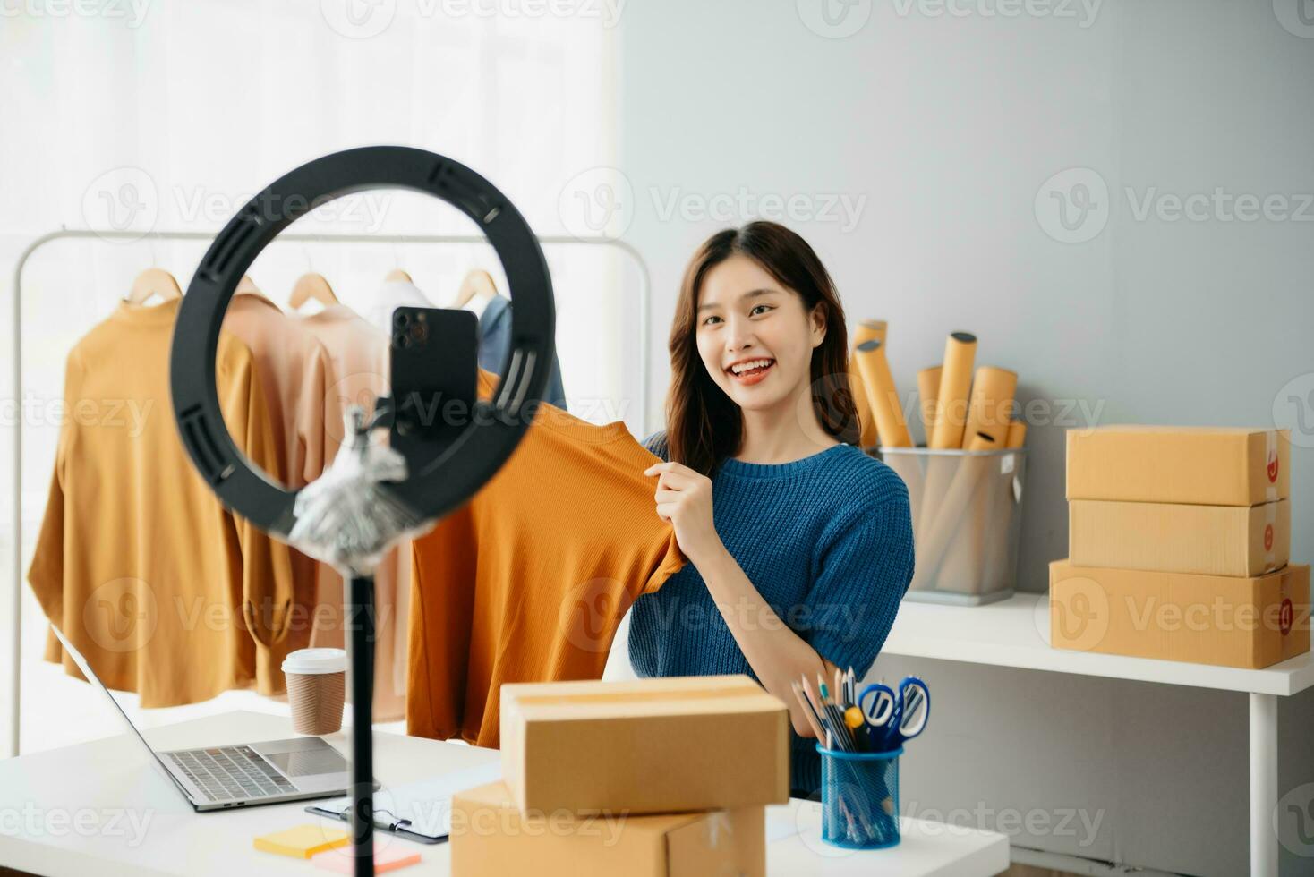Young woman running online store Startup small business SME, using smartphone or tablet taking receive and checking online purchase shopping photo