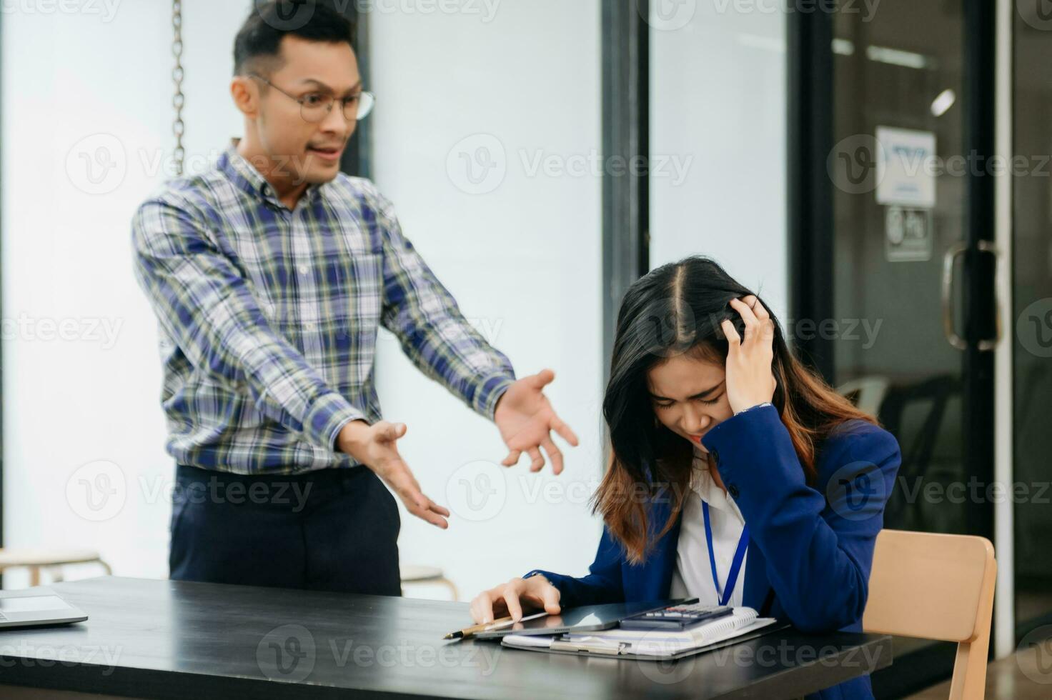 Furious two Asian businesspeople arguing strongly after making a mistake at work in office photo