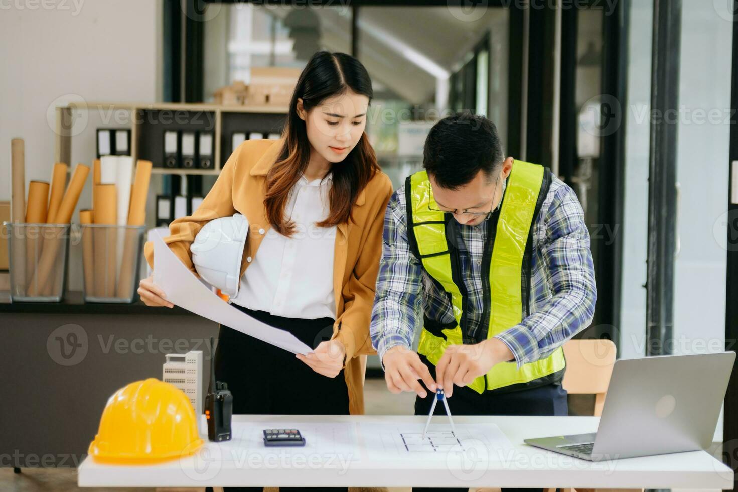 Engineer teams meeting working together wear worker helmets hardhat with on architectural project site and making model house. Asian industry professional team in modern office photo