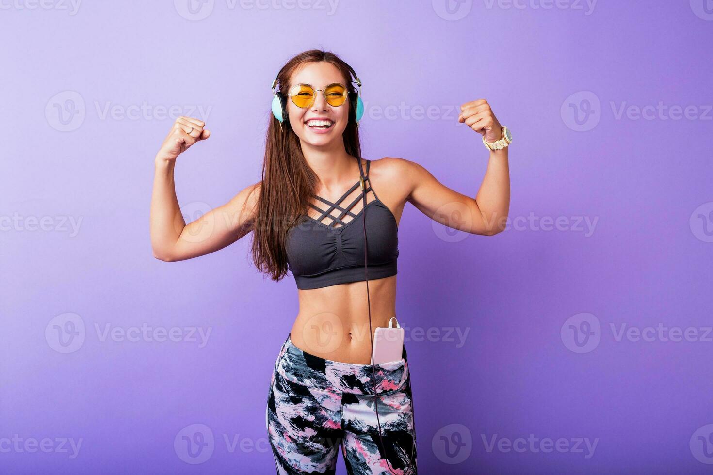 Exited sporty woman  demonstrate muscule in studio. photo