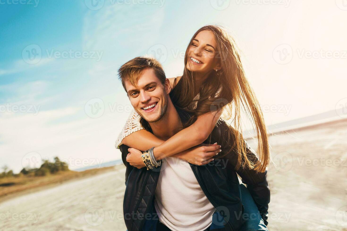 retrato hermosa sano joven adultos Novia y novio abrazando contento. joven bonito Pareja en amor Fechado en el soleado primavera a lo largo playa. calentar colores. estilo de vida mago foto