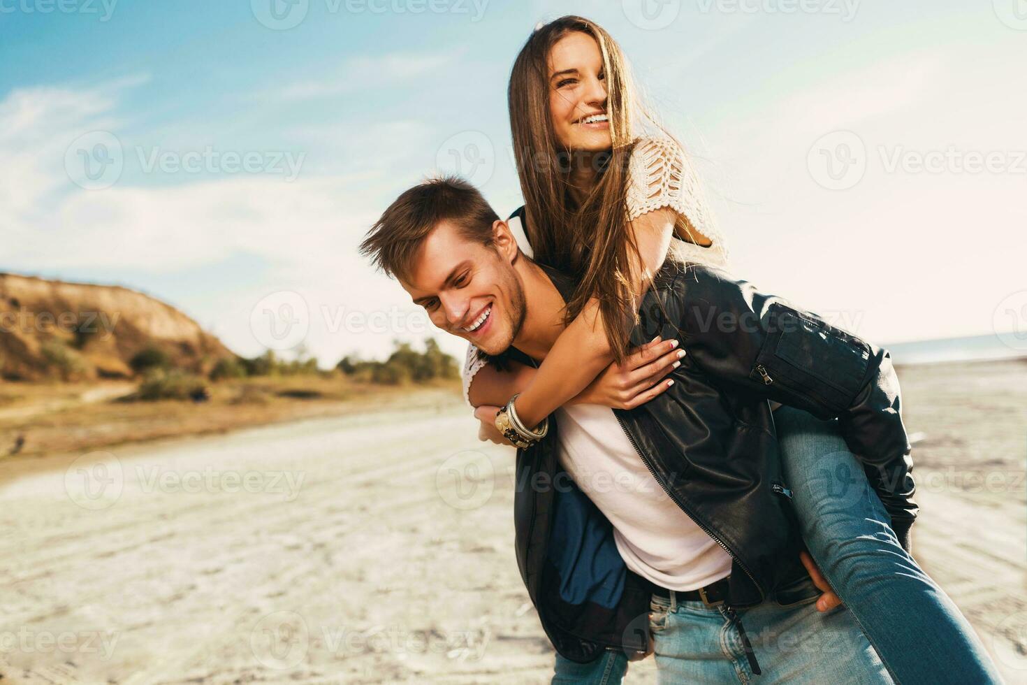 joven adultos Novia y novio abrazando contento. joven bonito Pareja en amor Fechado en el soleado primavera a lo largo playa. calentar colores. estilo de vida mago foto