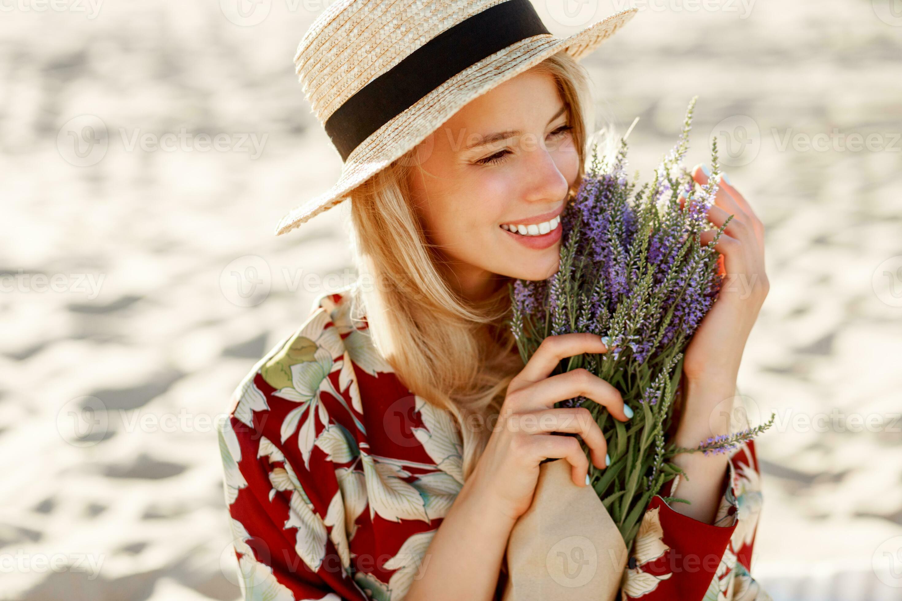 Romantic happy close up portrait of charming girl in straw hat smells
