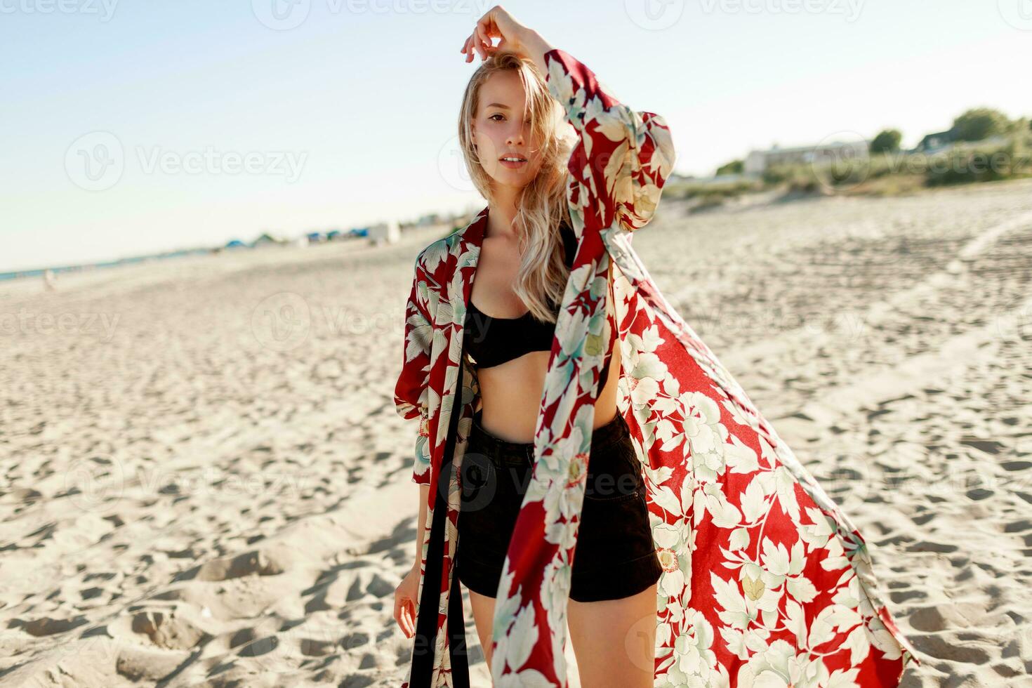 Blond woman on the beautiful beach wear dancing on sand. Sunset color. photo