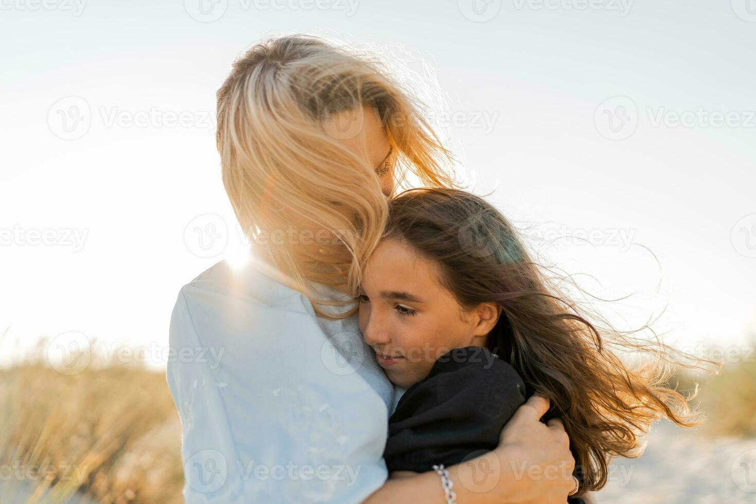 madre y hija abrazando en el playa. de la madre día, amar, familia, paternidad, infancia concepto. foto