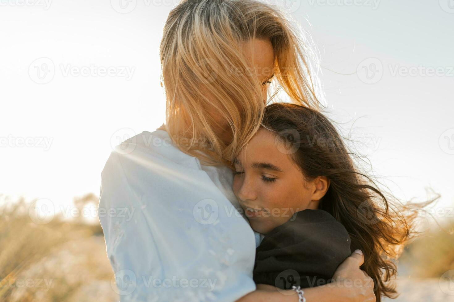madre y hija abrazando en el playa. de la madre día, amar, familia, paternidad, infancia concepto. foto