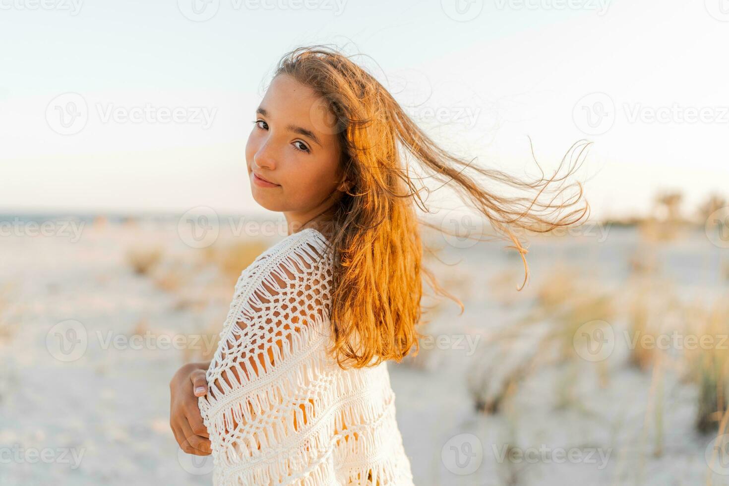 verano foto de pequeño niña en elegante boho atuendo posando en el playa. calentar puesta de sol colores. vacaciones y viaje concepto.