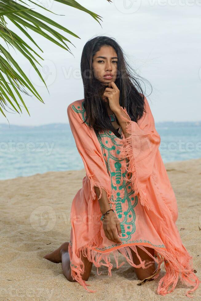 Amazing sexy tan asian woman posing on paradise tropical beach under the pam tree. photo