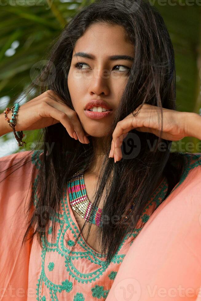 Close up beauty portrait of young asian woman on palm tree background. Perfect skin. photo