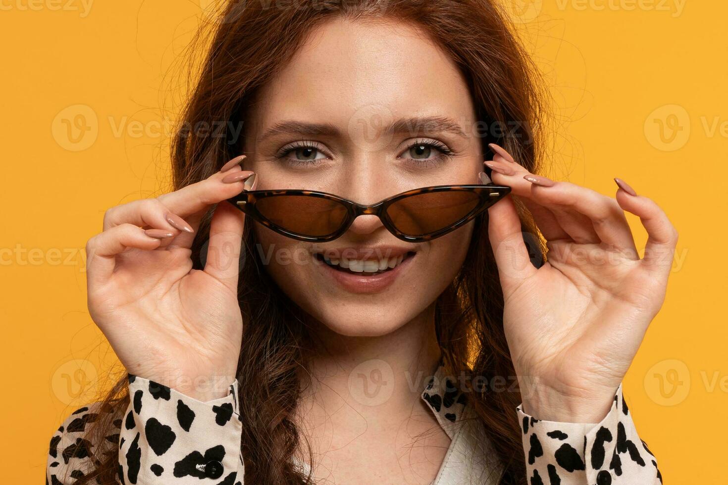 cerca arriba retrato de linda elegante rojo cabeza mujer posando en estudio en amarillo fondo foto