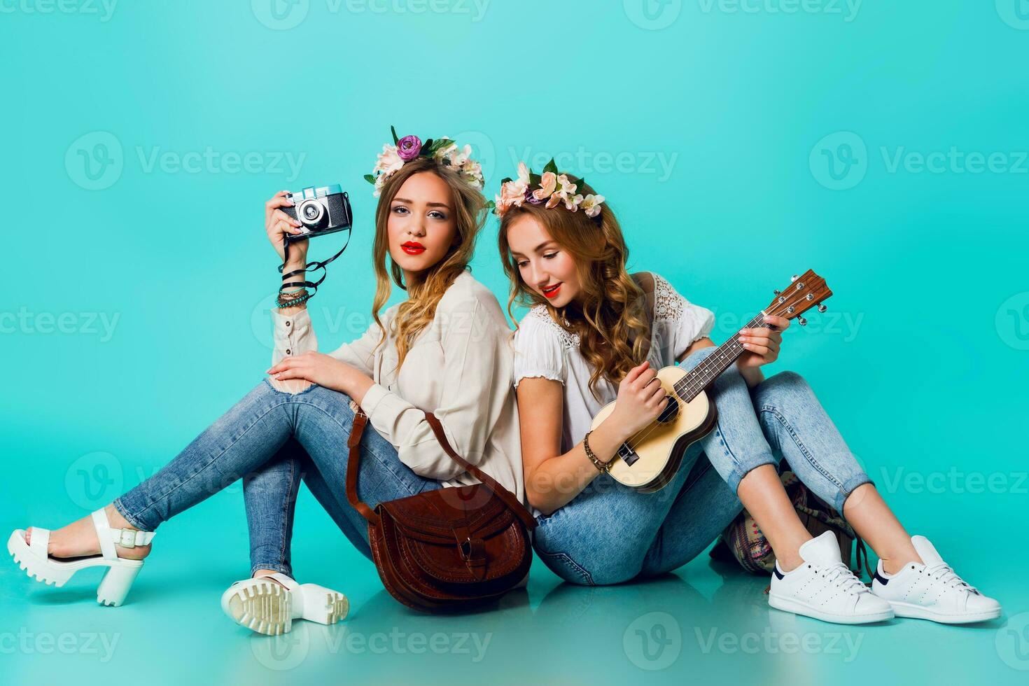 Studio lifestyle portrait of two pretty young blonde happy girls having fun. photo
