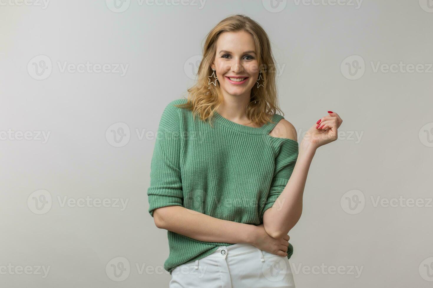 joven atractivo mujer en verde suéter, gris antecedentes foto