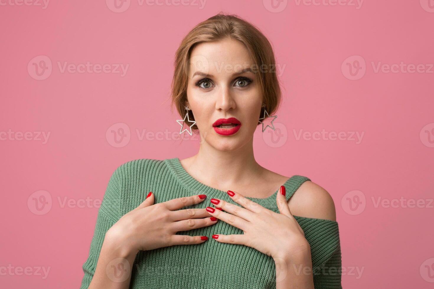 young attractive woman in green sweater, pink background photo