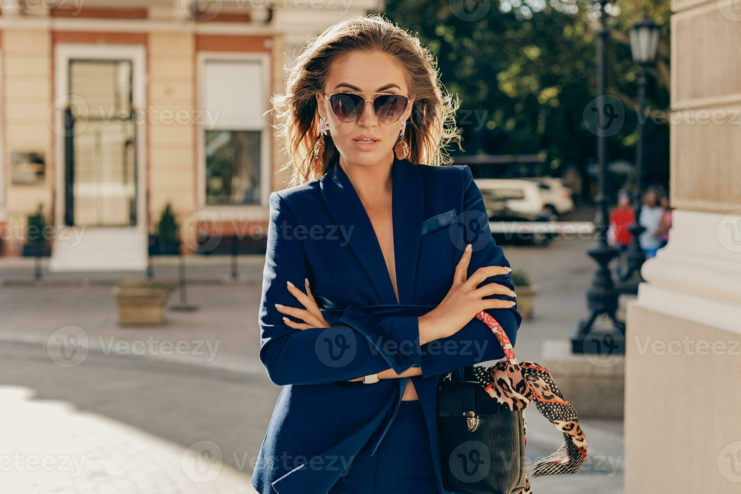 elegant attractive woman wearing blue stylish suit walking in street photo