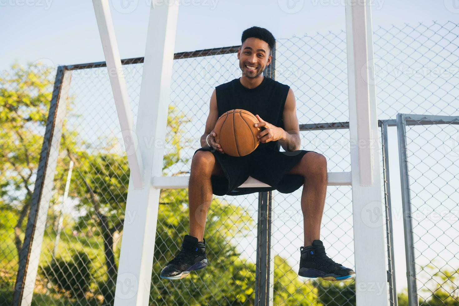 negro hombre haciendo Deportes, jugando baloncesto en amanecer, activo estilo de vida, soleado verano Mañana foto