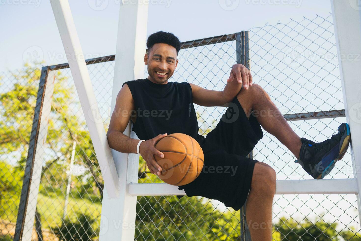 negro hombre haciendo Deportes, jugando baloncesto en amanecer, activo estilo de vida, soleado verano Mañana foto