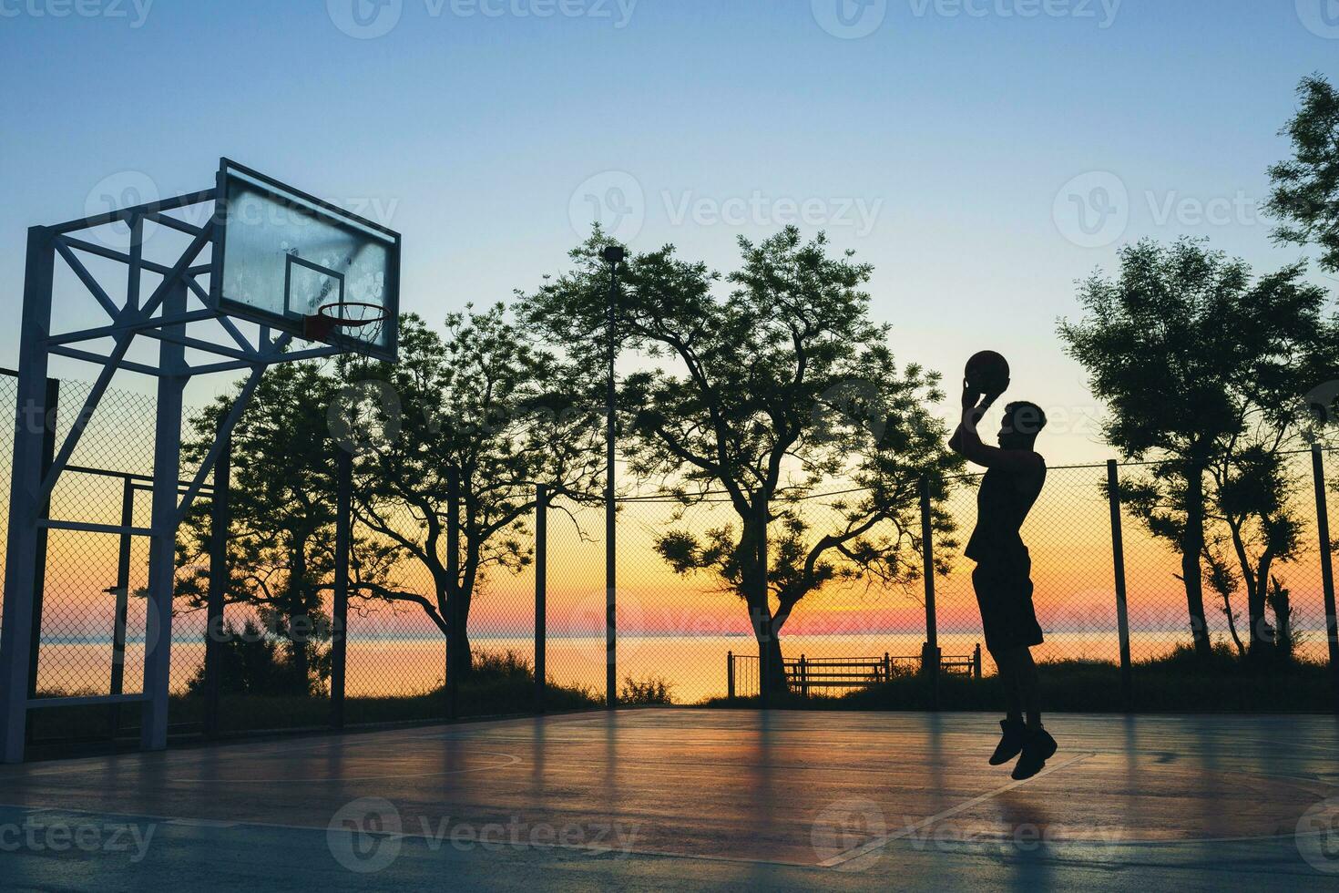 black man doing sports, playing basketball on sunrise, jumping silhouette photo