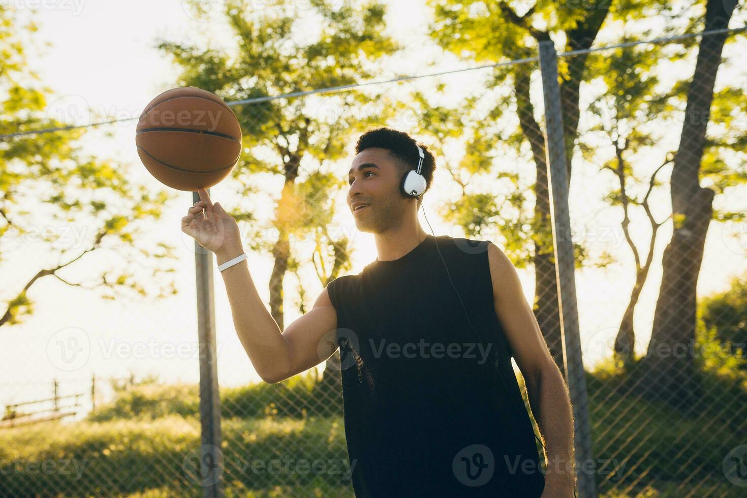 black man doing sports, playing basketball on sunrise, active lifestyle, sunny summer morning photo