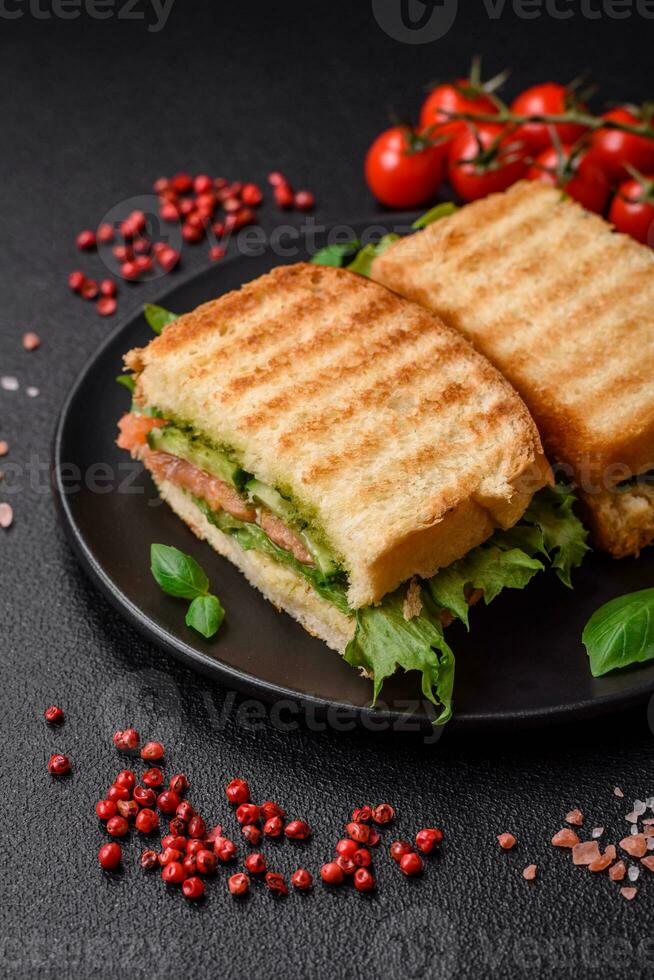 delicioso crujiente emparedado con tostada, salmón, palta, Tomates, sal, especias y hierbas foto