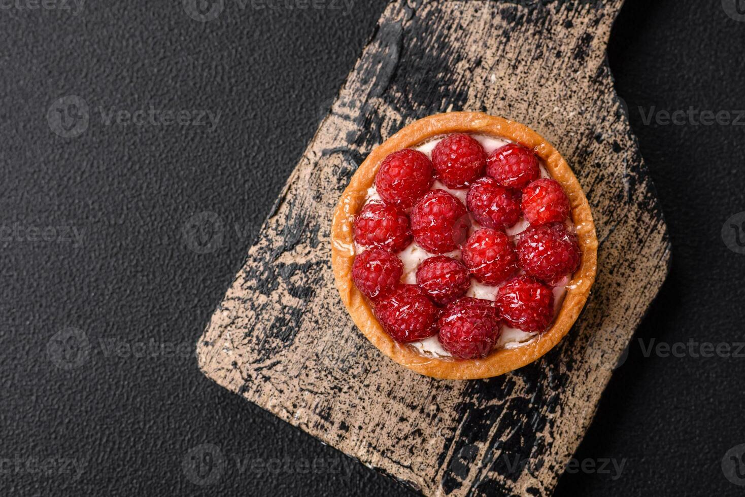 Delicious fresh sweet round tart with ripe raspberries and cream photo