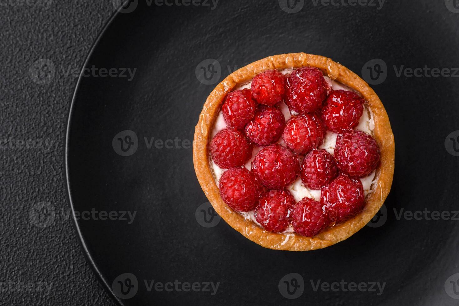 Delicious fresh sweet round tart with ripe raspberries and cream photo