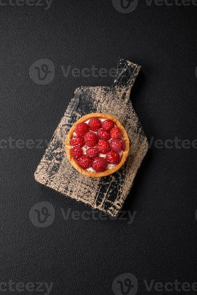 Delicious fresh sweet round tart with ripe raspberries and cream photo