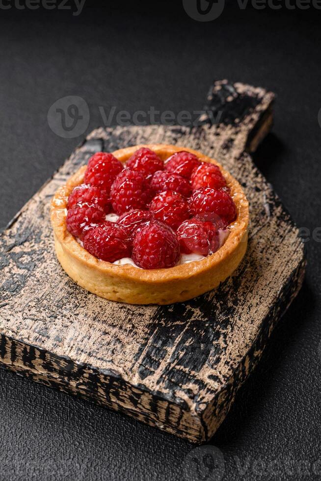 Delicious fresh sweet round tart with ripe raspberries and cream photo