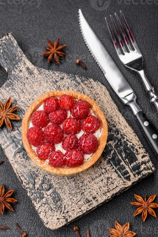 Delicious fresh sweet round tart with ripe raspberries and cream photo