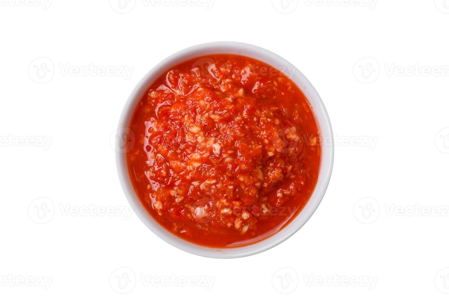 Delicious hot spicy red sauce with salt and spices in a ceramic bowl photo