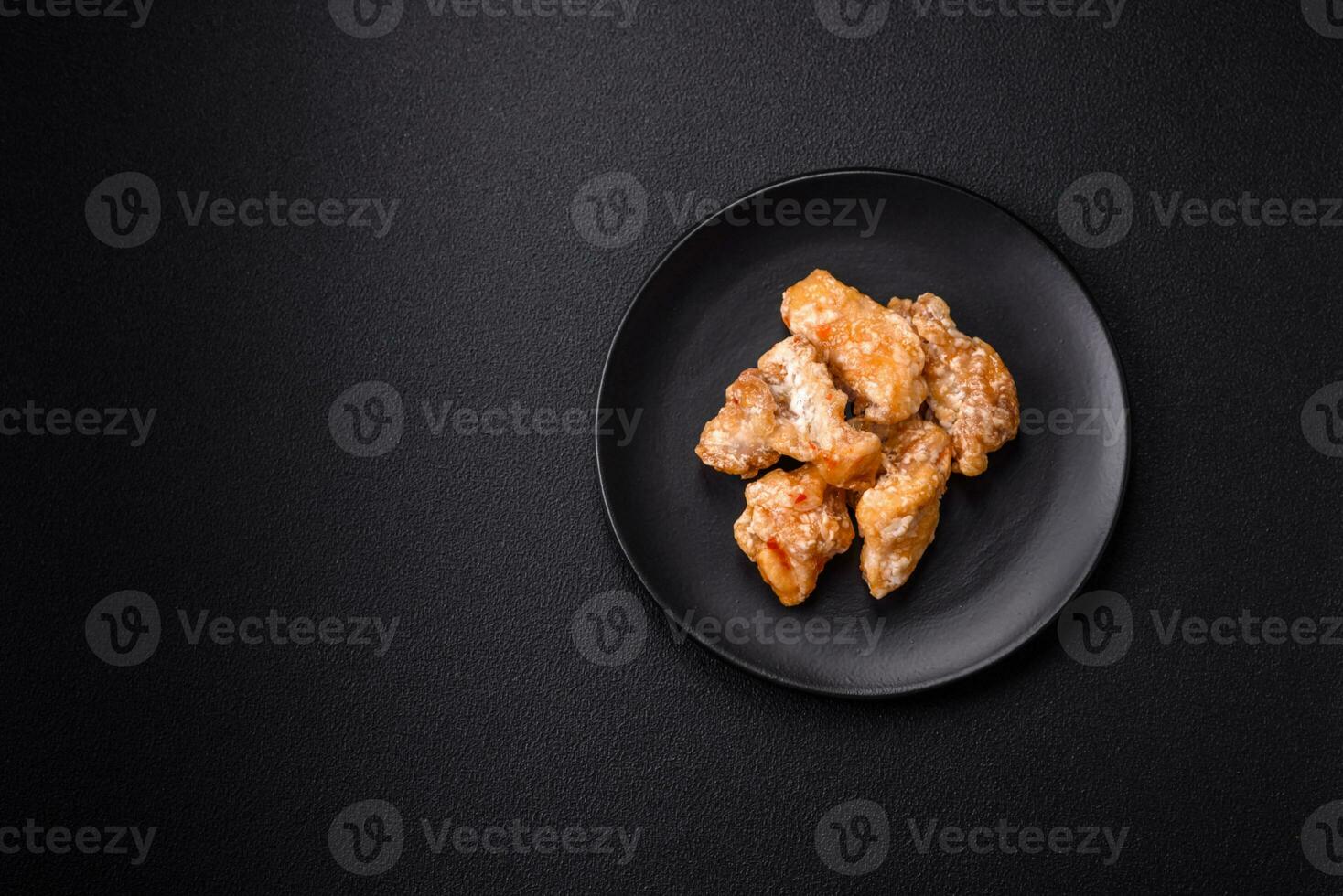 Delicious juicy grilled chicken pieces in sweet and sour sauce with salt and spices photo