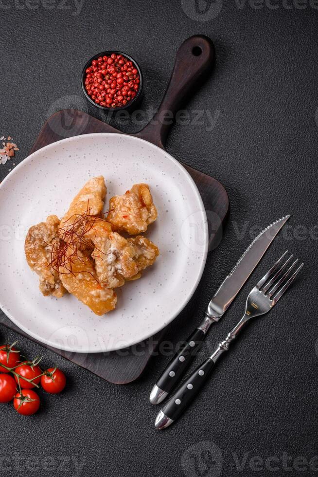 Delicious juicy grilled chicken pieces in sweet and sour sauce with salt and spices photo