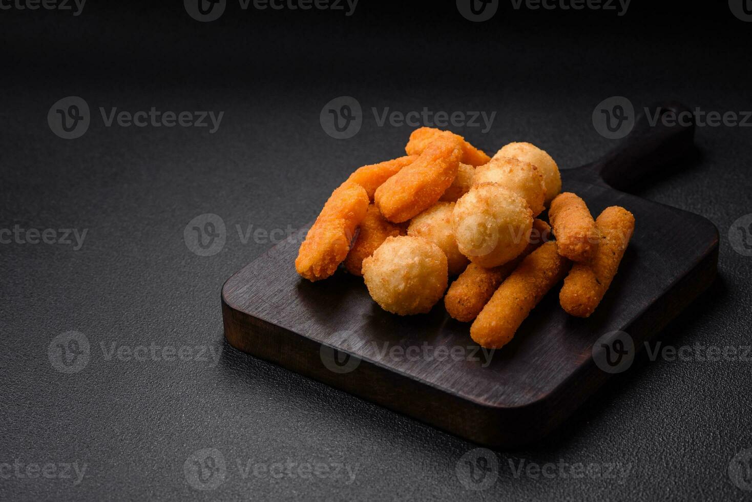 Delicious nuggets, sticks and balls of mozzarella and parmesan cheese with salt and spices photo