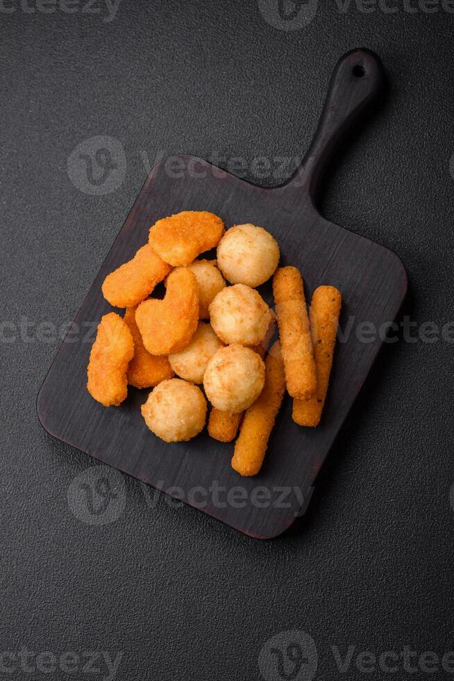 Delicious nuggets, sticks and balls of mozzarella and parmesan cheese with salt and spices photo