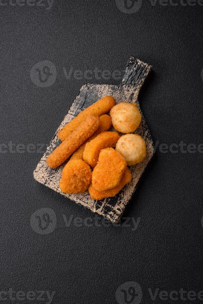 Delicious nuggets, sticks and balls of mozzarella and parmesan cheese with salt and spices photo