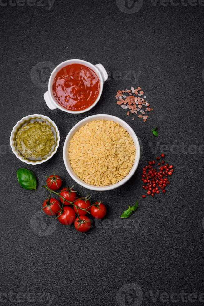 Raw whole grain orzo pasta as an ingredient for a delicious dish photo