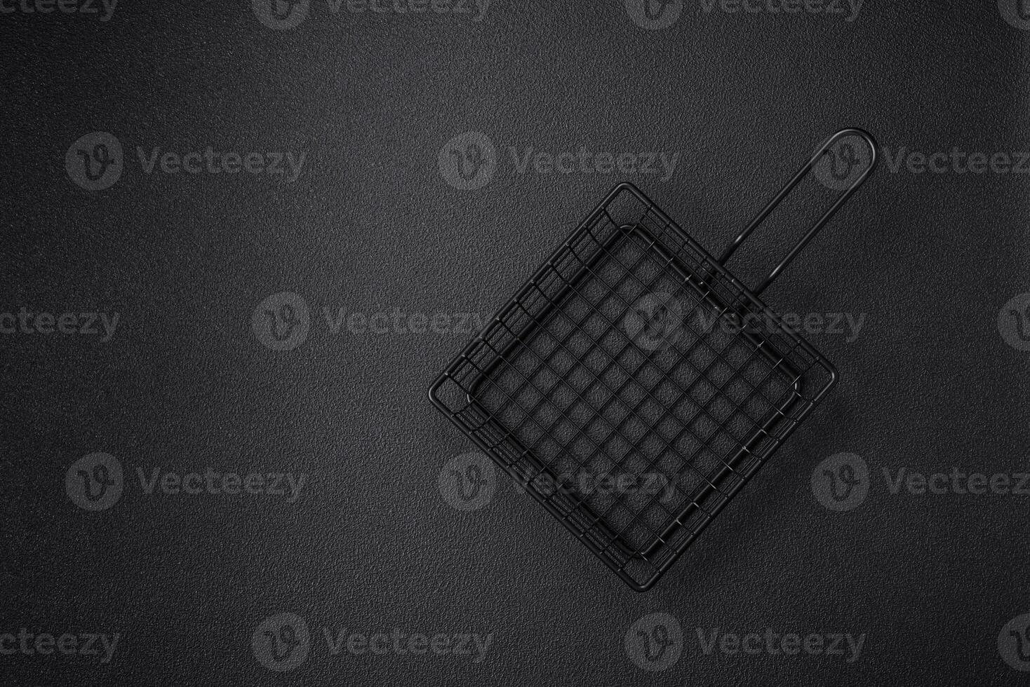 A black mesh or basket for deep-frying and cooking potatoes in boiling oil photo