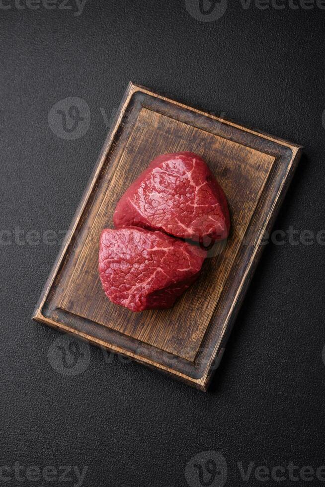 Fresh juicy raw beef medallions with salt and spices photo