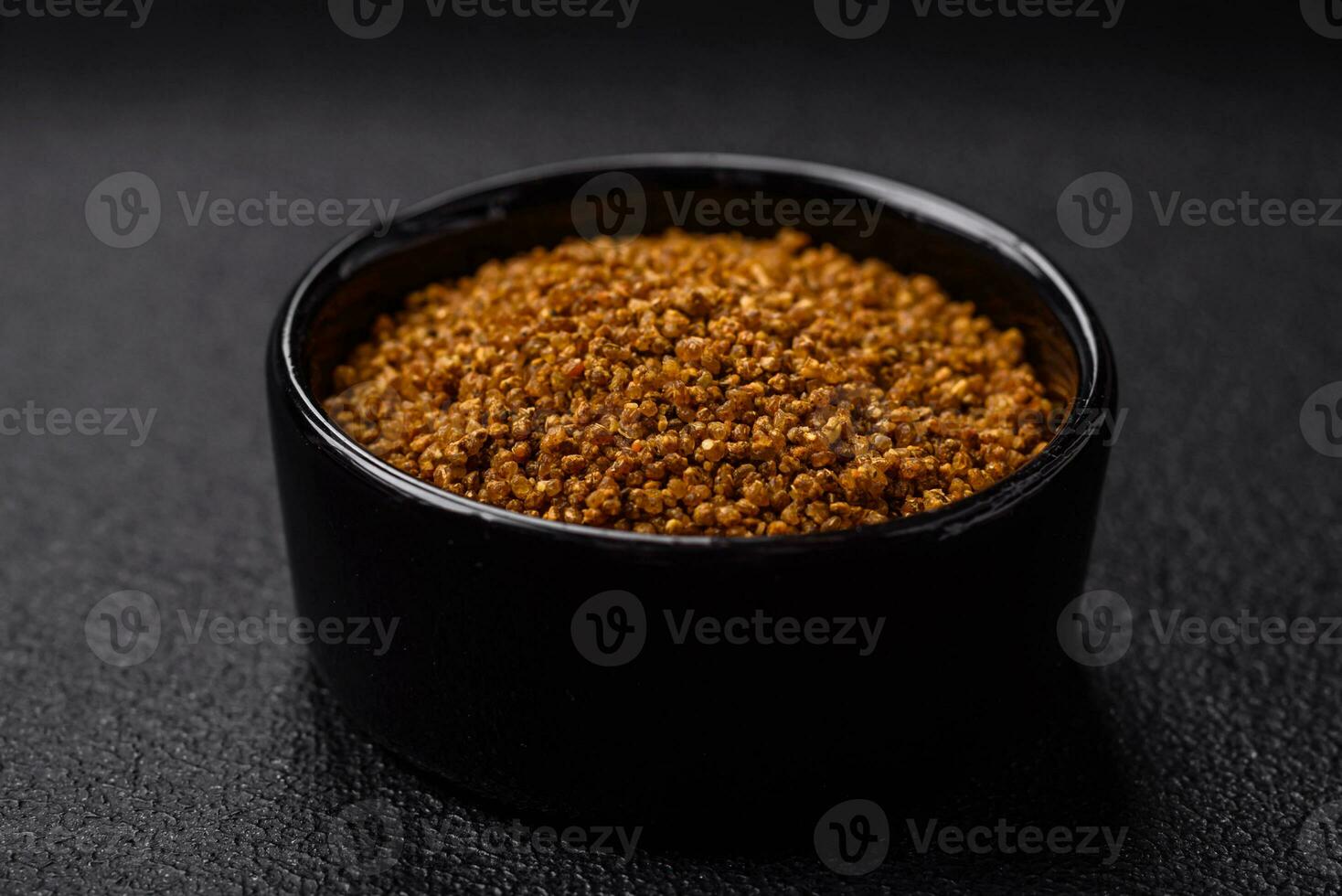 Crystals of brown Svan salt with spices in a black bowl photo
