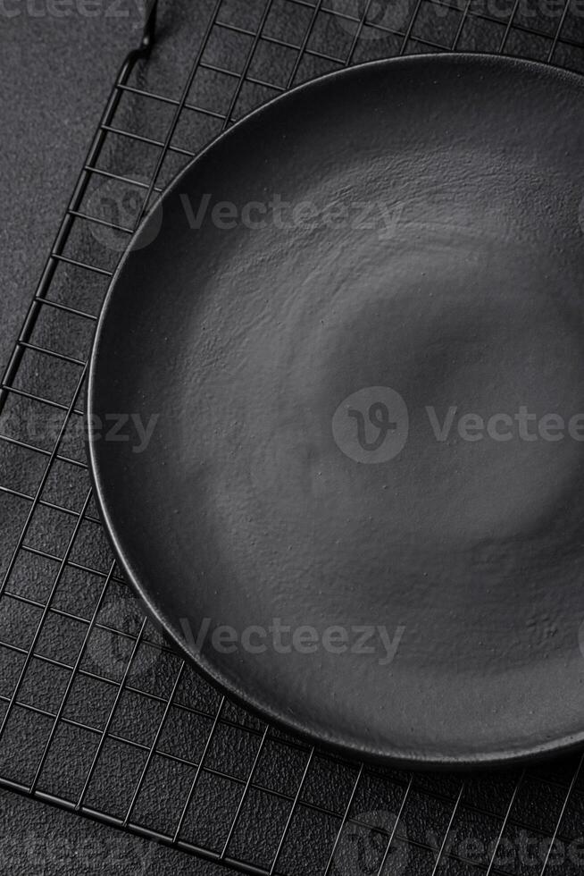 Empty ceramic round plate on dark textured concrete background photo