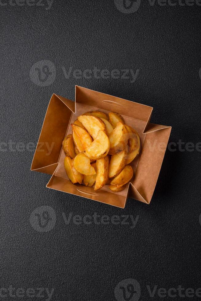 Delicious crispy fried potato wedges with salt, spices and herbs photo