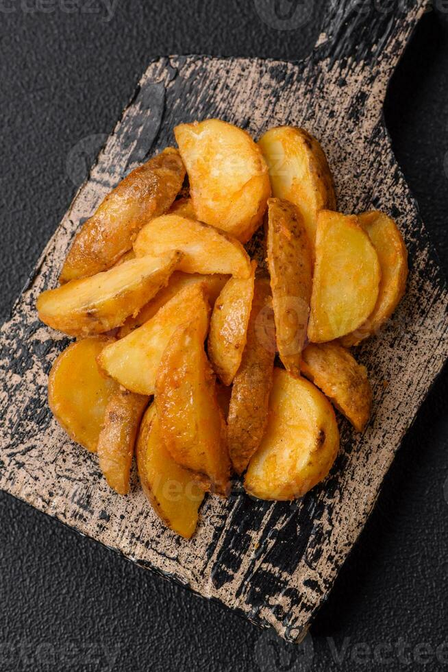 Delicious crispy fried potato wedges with salt, spices and herbs photo