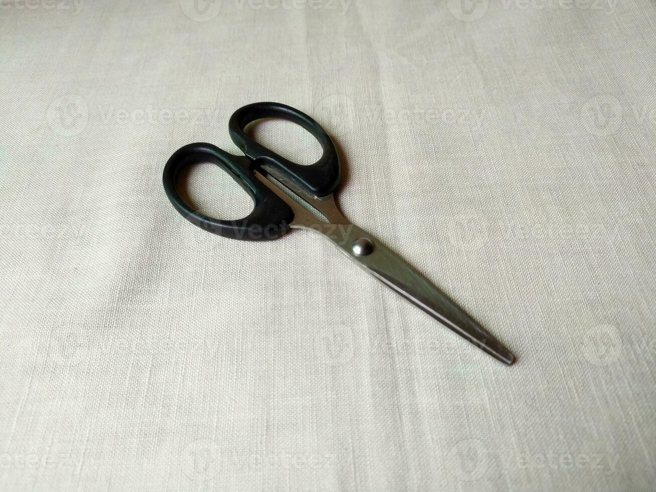 A pair of sharp scissors was wide open on table photo